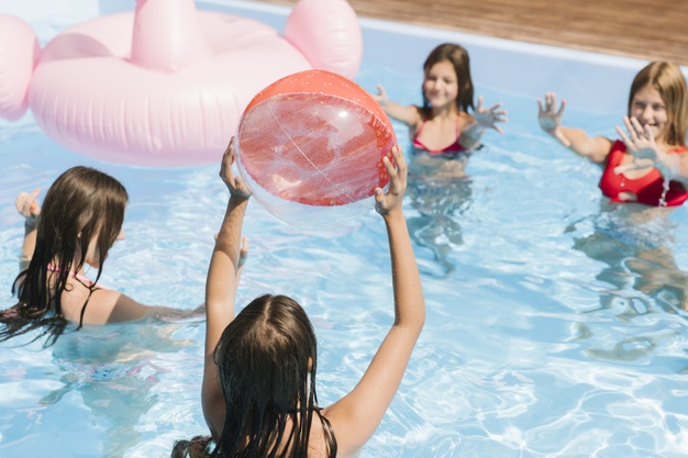 4 filles qui jouent au ballon dans une piscine