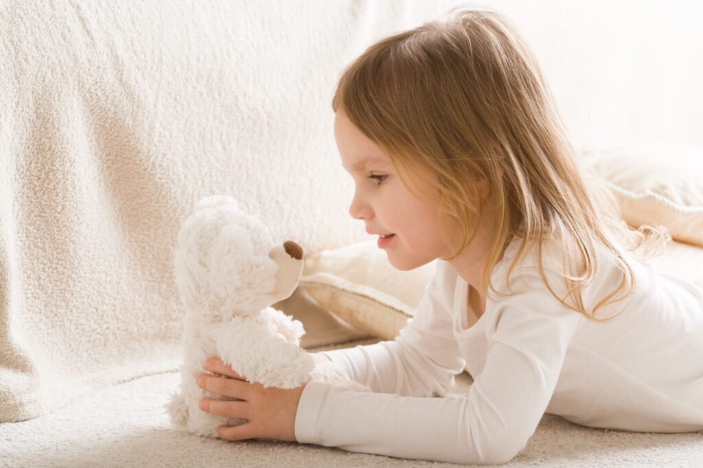 petite fille qui joue avec sa peluche