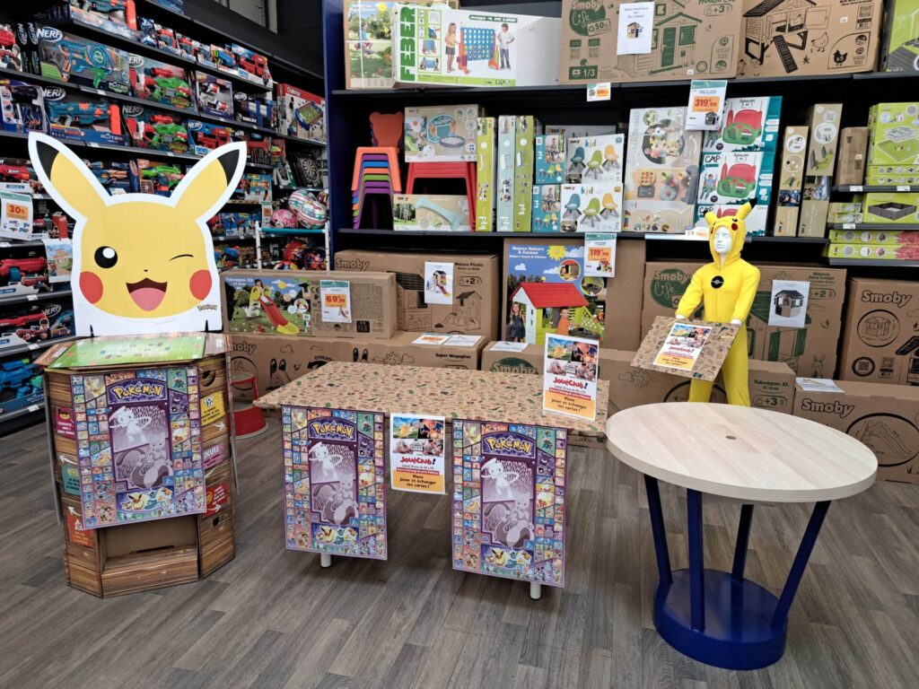 installation d'un atelier Pokémon en magasin joueclub avec table, affiches, déguisements, PLV à l'effigie de pikachu